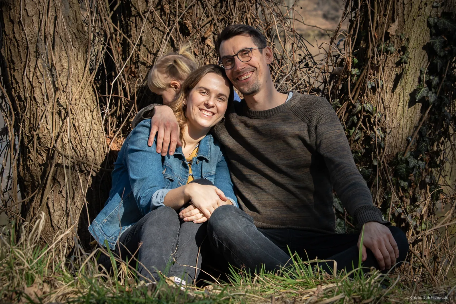 Familie sitzt gemütlich unter einem Baum